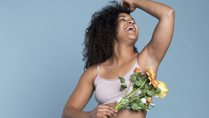 Curvy woman, laughing, holding a flower bouquet